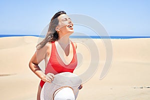 Young beautiful woman sunbathing wearing summer swinsuit at maspalomas dunes bech