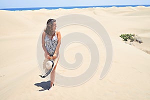 Young beautiful woman sunbathing wearing summer swinsuit at maspalomas dunes bech