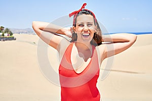 Young beautiful woman sunbathing wearing summer swinsuit at maspalomas dunes bech