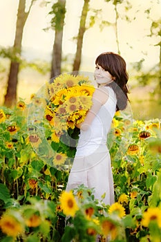 Young beautiful woman in a sunflower field