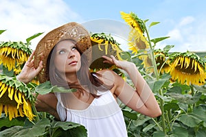 young beautiful woman between sunflowers