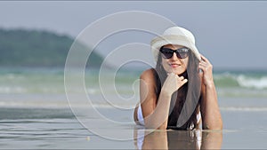 Young beautiful woman in sunglasses relaxing and sunbathing at tropical beach