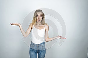 Young beautiful woman surprised showing scales sign isolated white background