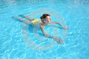 Young beautiful woman swimming in paddling pool