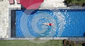 The young beautiful woman swims in the pool, flat lay, dron view photo