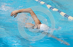 Young beautiful woman with swimsuit swimming on a blue water pool