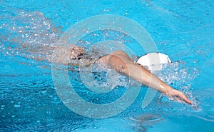 Young beautiful woman with swimsuit swimming on a blue water pool