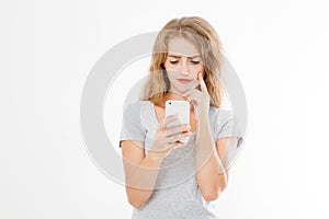 Young beautiful woman in t shirt using her smartphone isolated on white background. blond girl chating with friend