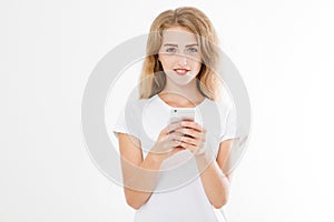 Young beautiful woman in t shirt using her smartphone isolated on white background. blond girl chating with friend or shoppin