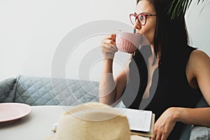 Young beautiful woman at a table in a cafe talking on the phone.