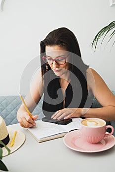 Young beautiful woman at a table in a cafe talking on the phone.