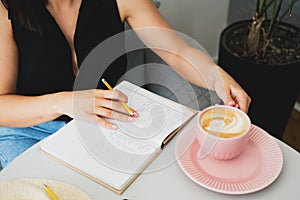 Young beautiful woman at a table in a cafe talking on the phone.