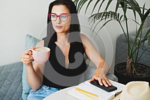 Young beautiful woman at a table in a cafe talking on the phone.