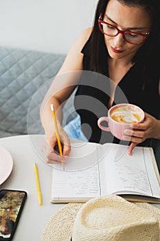 Young beautiful woman at a table in a cafe talking on the phone.