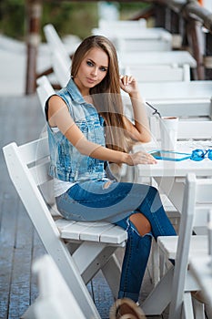 Young beautiful woman at a table in summer cafe