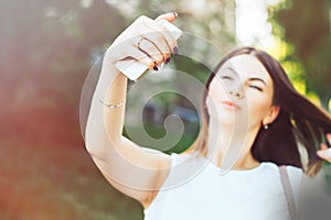 young beautiful woman, teenager, making selfie in park, girl is unfocused, focus on smartphone