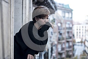 Young beautiful woman thinking and feeling sad suffering depression at urban city background home balcony