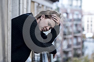 Young beautiful woman thinking and feeling sad suffering depression at urban city background home balcony