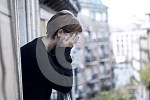 Young beautiful woman thinking and feeling sad suffering depression at urban city background home balcony