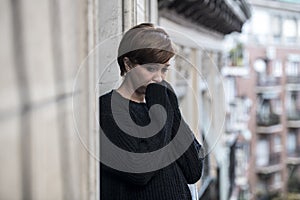Young beautiful woman thinking and feeling sad suffering depression at urban city background home balcony
