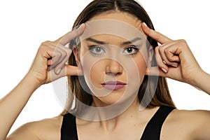 Young beautiful woman tightening her face skin with her fingers