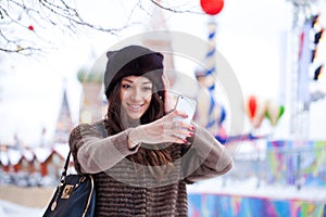 Young beautiful woman tourist taking pictures on mobile phone