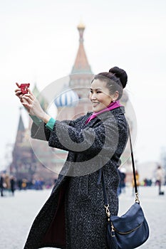 Young beautiful woman tourist taking pictures on mobile phone