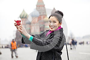 Young beautiful woman tourist taking pictures on mobile phone