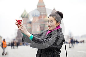 Young beautiful woman tourist taking pictures on mobile phone