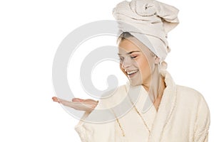 Young beautiful woman with towel on her head holding imaginary object