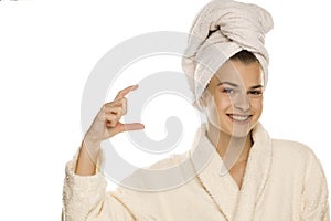 Young beautiful woman with towel on her head holding imaginary object