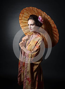 Young beautiful woman in traditional japanese kimono with umbrella.