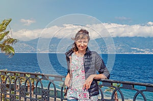 Young beautiful woman traveler looking camera, smile and posing on embankment Lungomare Falcomata in Reggio Calabria