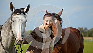 Young beautiful woman and two horses