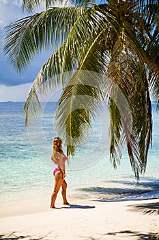 Young beautiful woman under the palm tree, tropical vacation