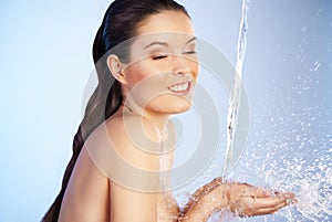 Young beautiful woman under the stream of water