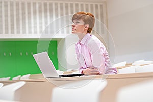 Young beautiful woman on a university lecture working on a laptop