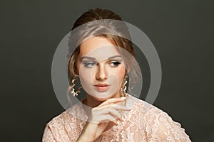 Young beautiful woman with updo hairdo on dark background