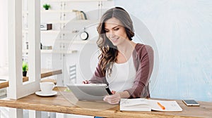 Young beautiful woman using digital tablet at home, Cheerful smiling girl sitting at her workplace