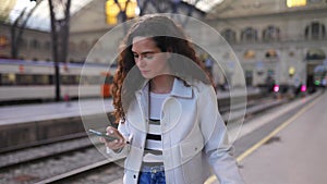 Young beautiful woman using smart phone at platform station