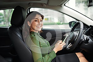 Young beautiful woman using smartphone while driving car