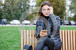 Young beautiful woman using smartphone in the park