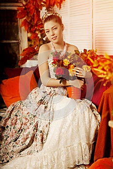 Young beautiful woman in vintage dress on autumn porch. Beauty g