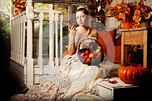 Young beautiful woman in vintage dress on autumn porch. Beauty g