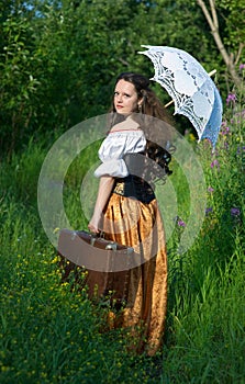 Young beautiful woman in vintage dress with old su