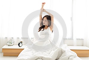 Young beautiful woman waking up happy after healthy sleep stretching on comfortable bed. Sweet dreams, good morning, new day,