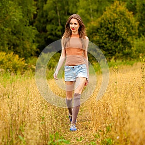 Young beautiful woman walking in a field, summer outdoors