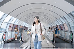 Young beautiful woman walking with suitcase , check in at International airport , vacation travel and transportation concept