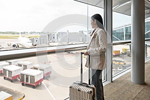 Young beautiful woman walking with suitcase , check in at International airport , vacation travel and transportation concept