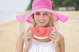 Young beautiful woman with watermelon wearing pink sunhat